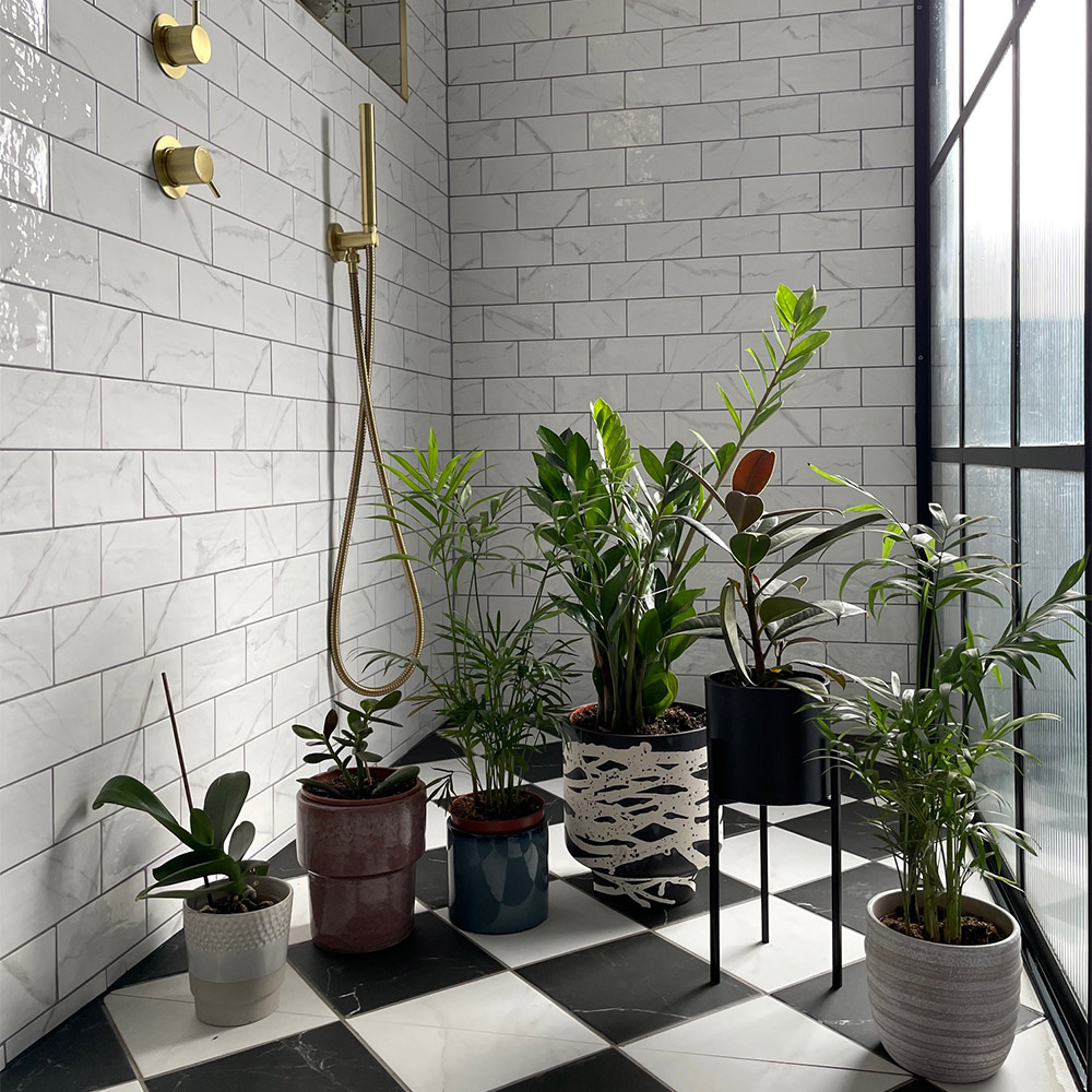 marble checkerboard flooring and white marble wall tiles with various green plants and gold accessories