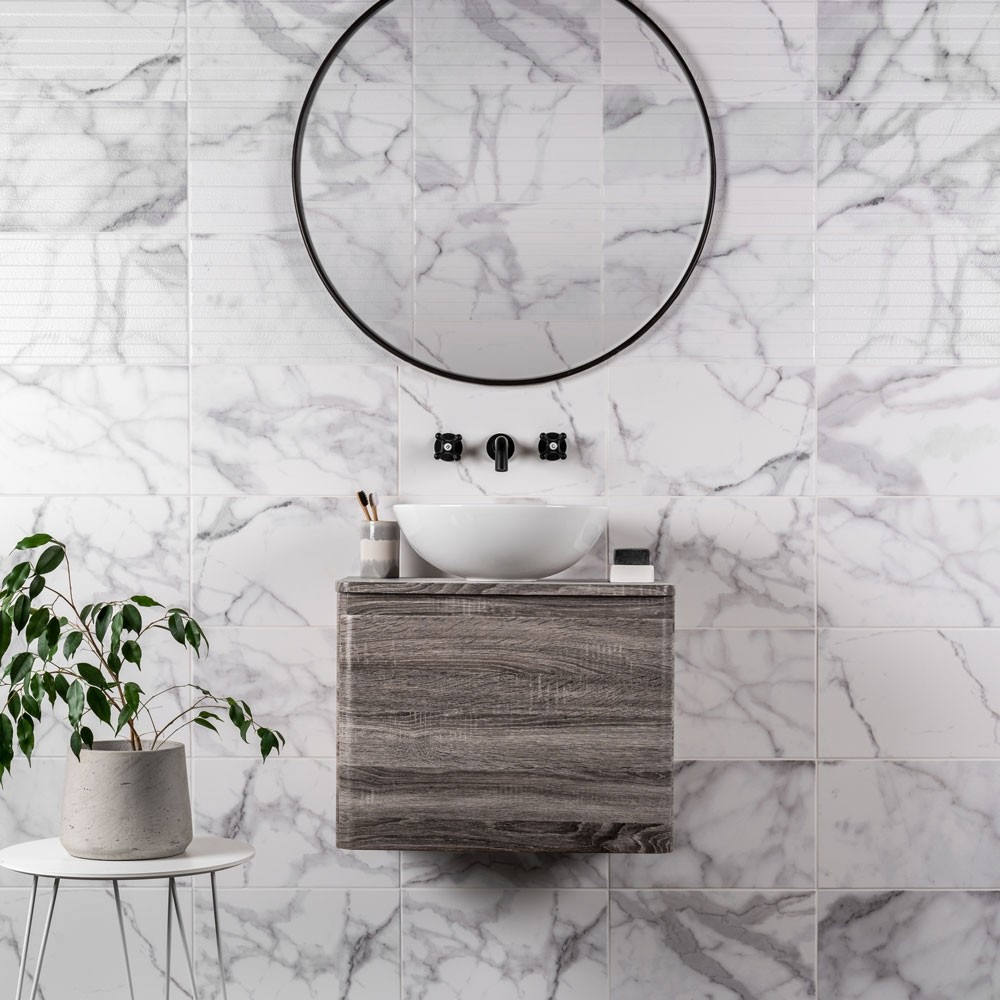 Strong grey marble effect tiles across splashback in bathroom, with grey wood wall mounted vanity sink basin unit and matt black taps.
