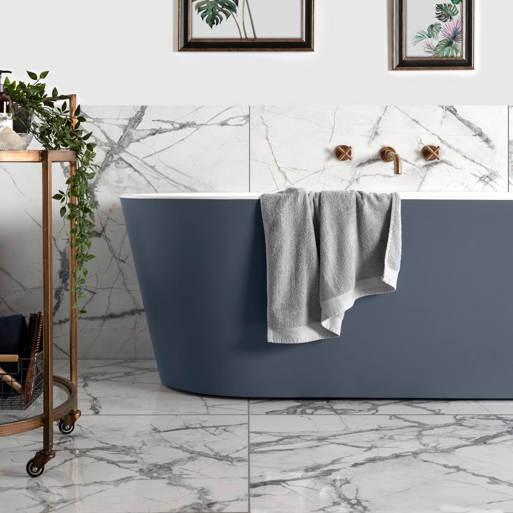 Grey marble effect bathroom with modern grey freestanding bath tub. Gold accessories throughout modern bathroom.