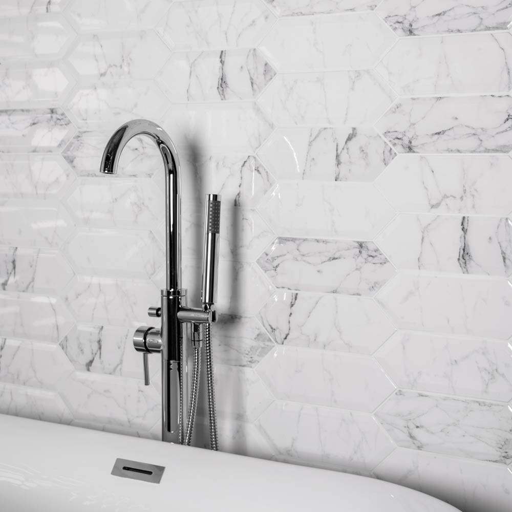 Hexagonal white marble wall tiles with modern chrome bath mixer tap.