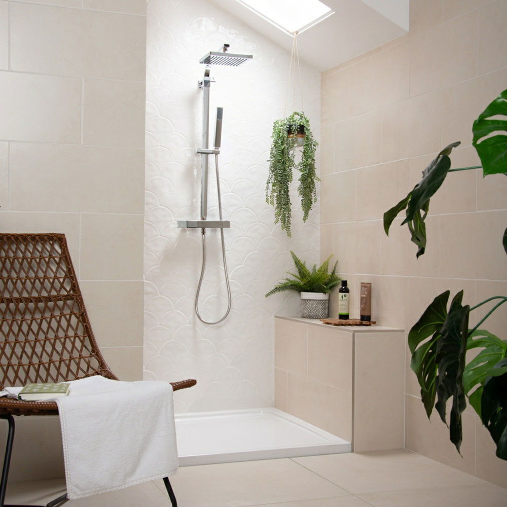 Bright neutral bathroom design using creams and whites, with multiple house plants throughout space.