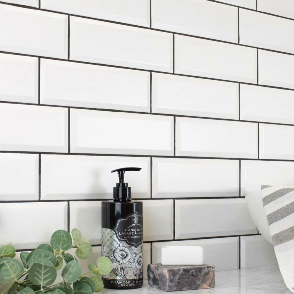 Simple white brick bond tiles with black grout.