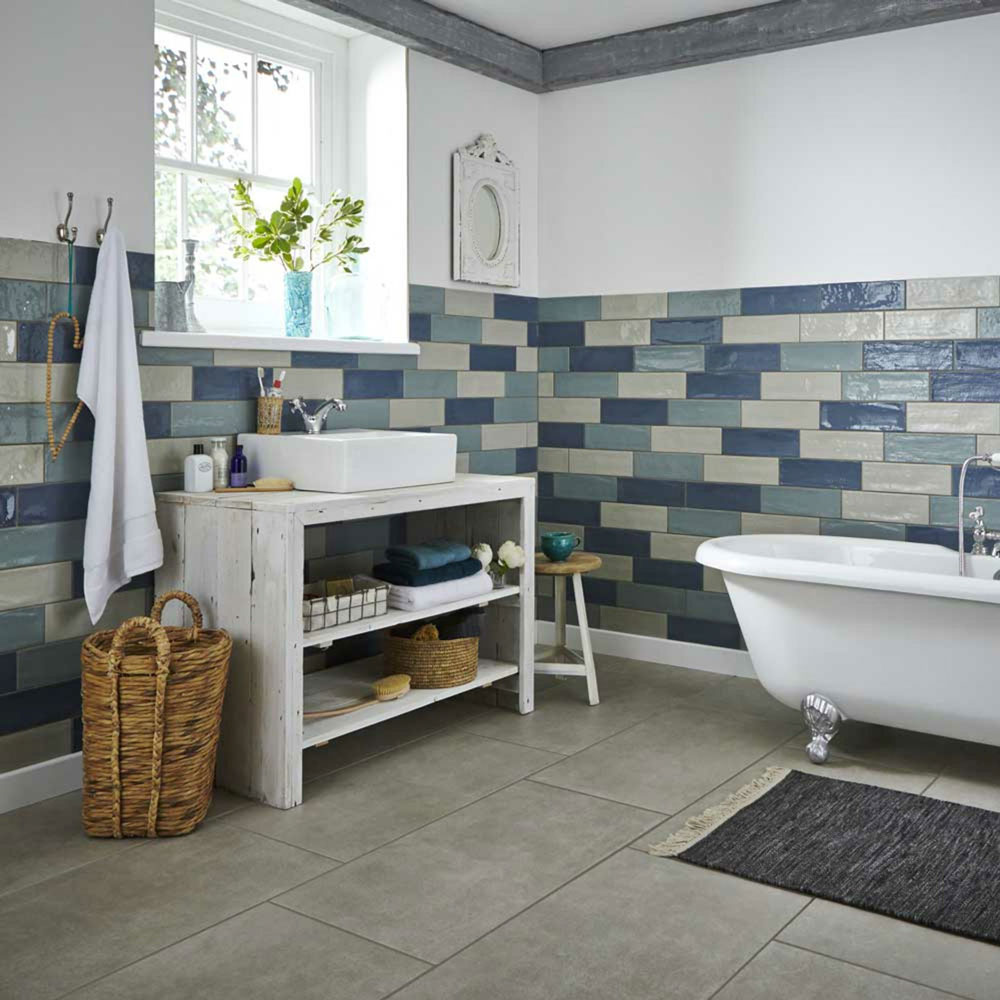 Bathroom space using blue multi toned brick bond tiles, with under sink storage.