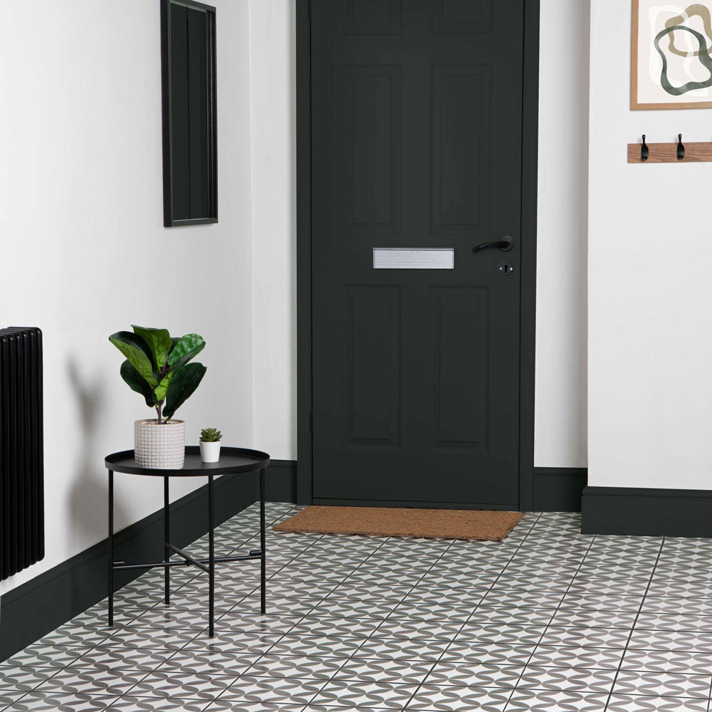 Black and white flooring with black front door and side table.
