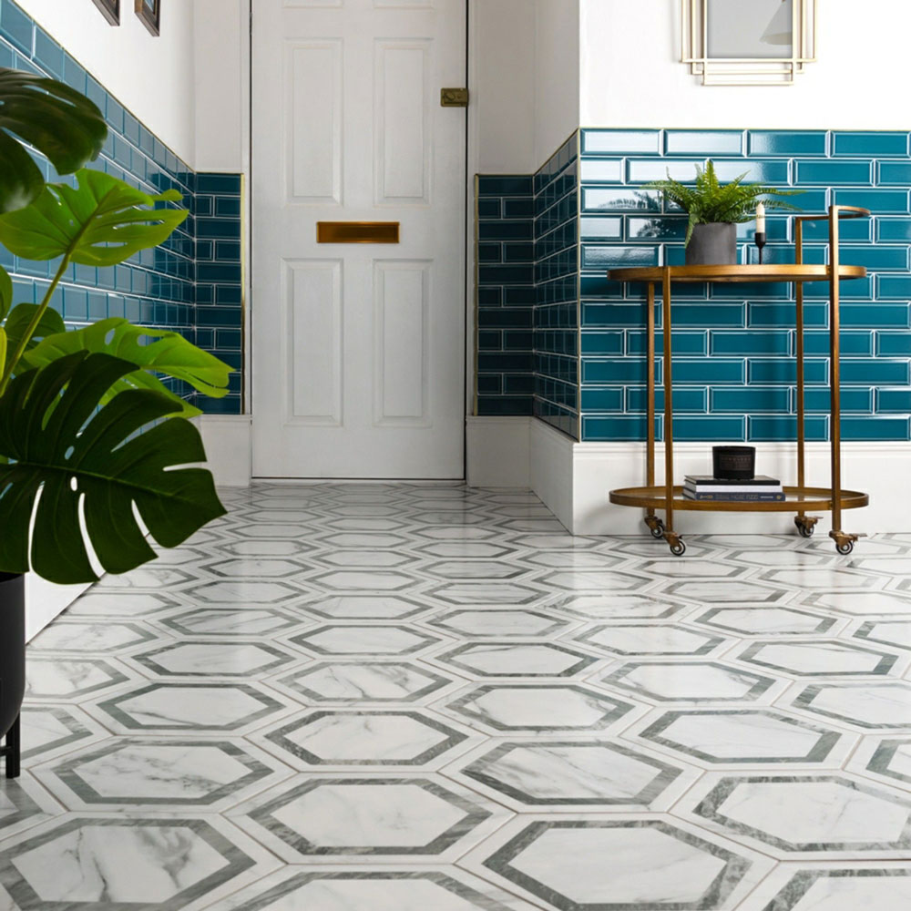 Hexagonal marble flooring with bright blue panelling surrounding hallway. 