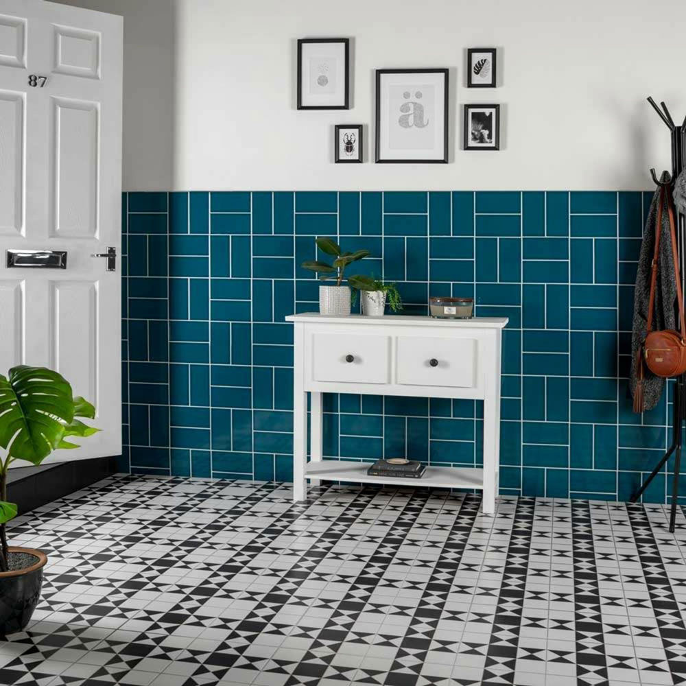 Geometric black and white flooring with unconventional blue tiles across wall. 