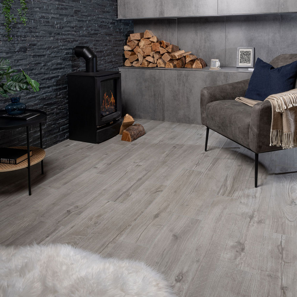Grey wood effect floor tiles in living area with fireplace.