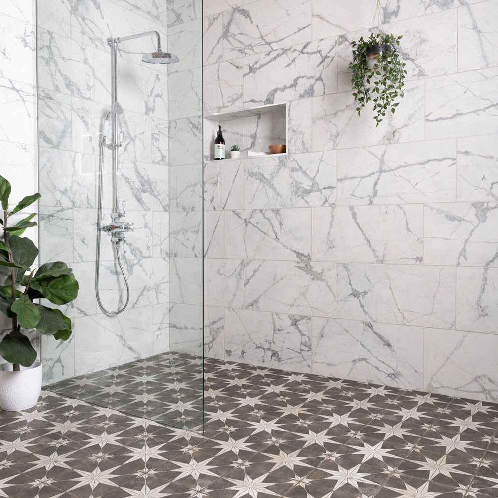 Black and white star pattern floor tiles with marble wall tiles in wet room area.