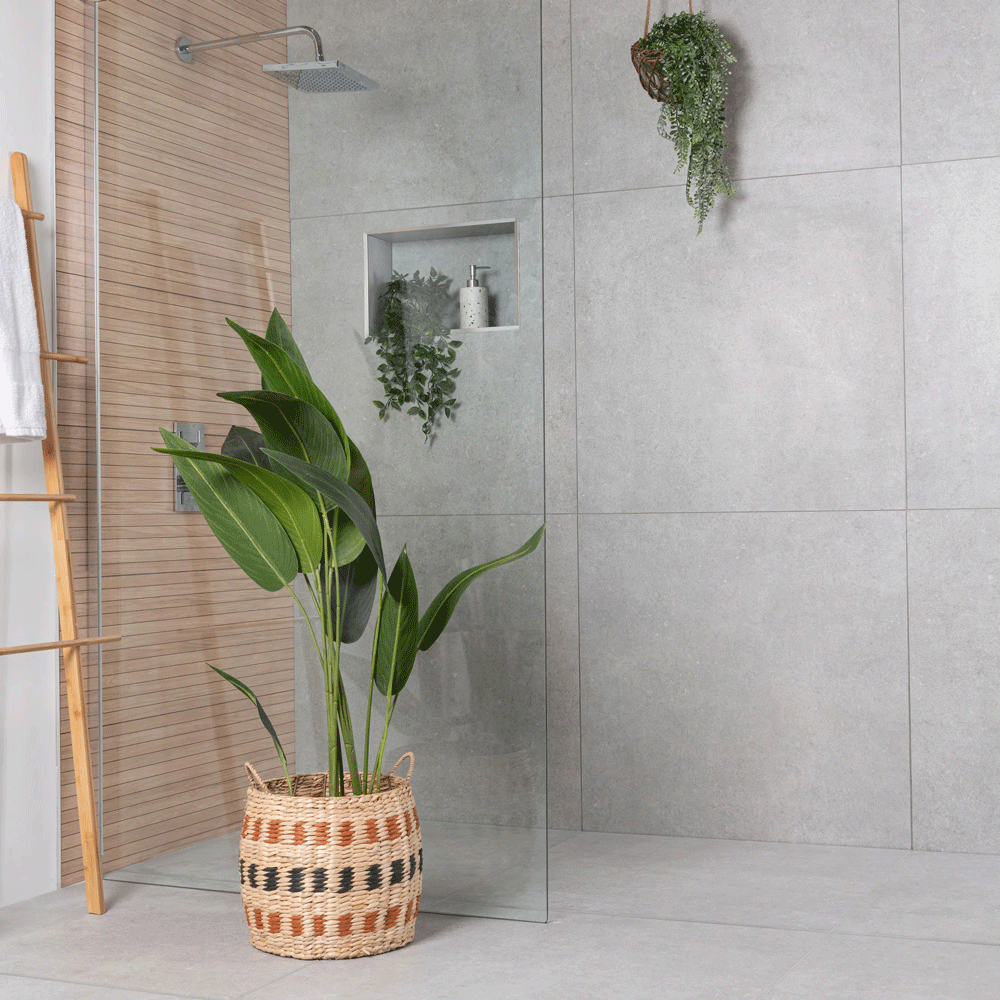 Light grey stone effect tiles throughout shower area, spa atmosphere is enhanced by large potted plant and greenery throughout. 