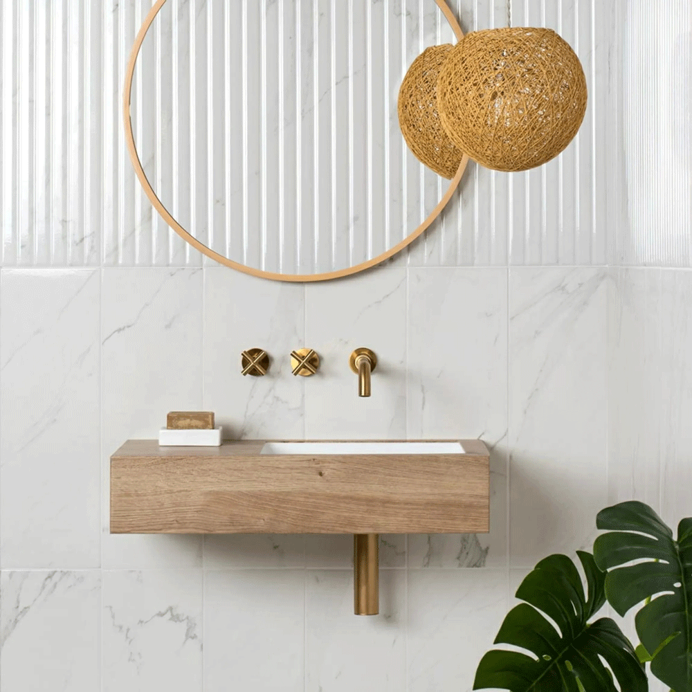 Clean and elegant white bathroom scheme using wood textures and gold hardware to enhance home spa bathroom feel.