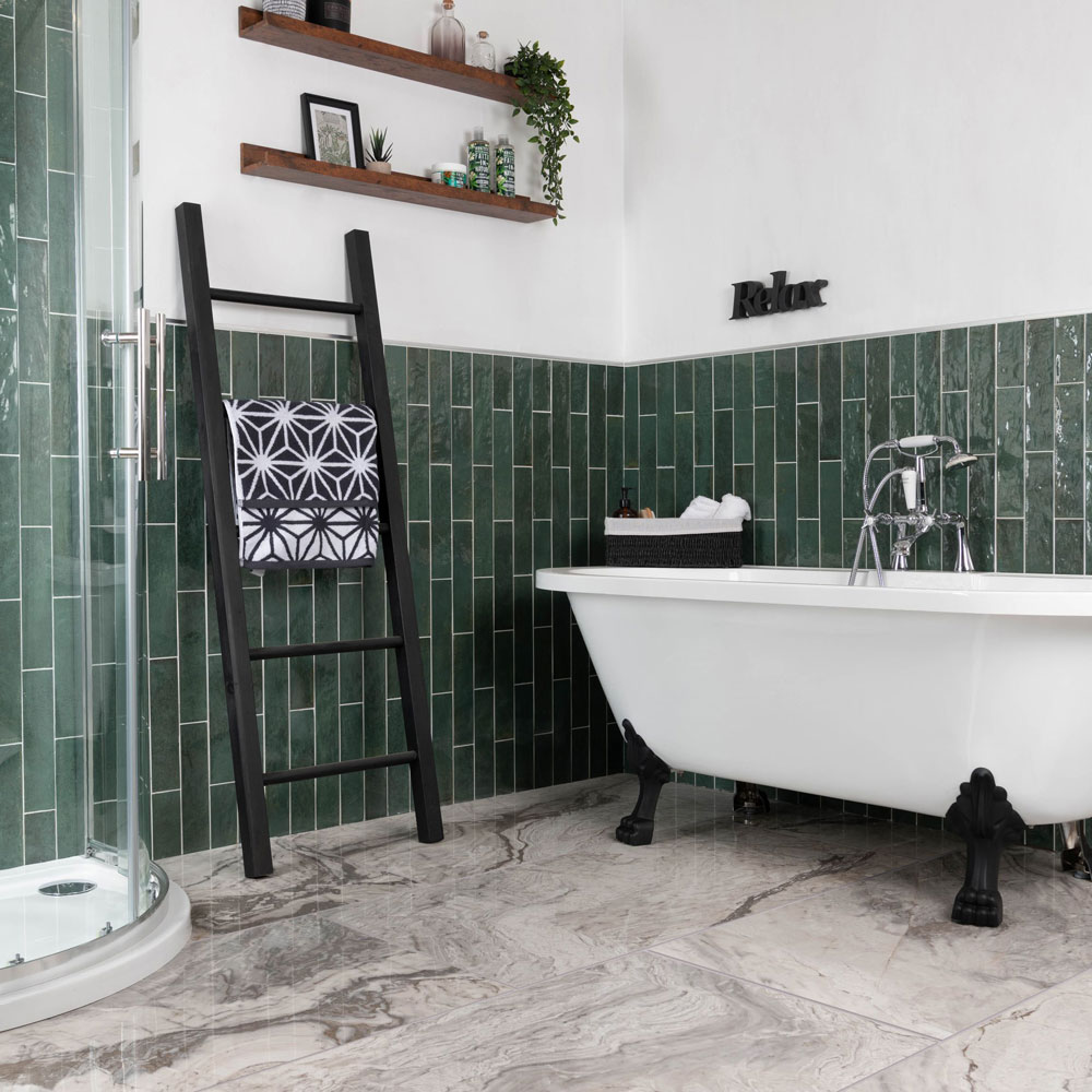Deep green metro tiles with striking marble flooring and black and white bathroom scheme. 
