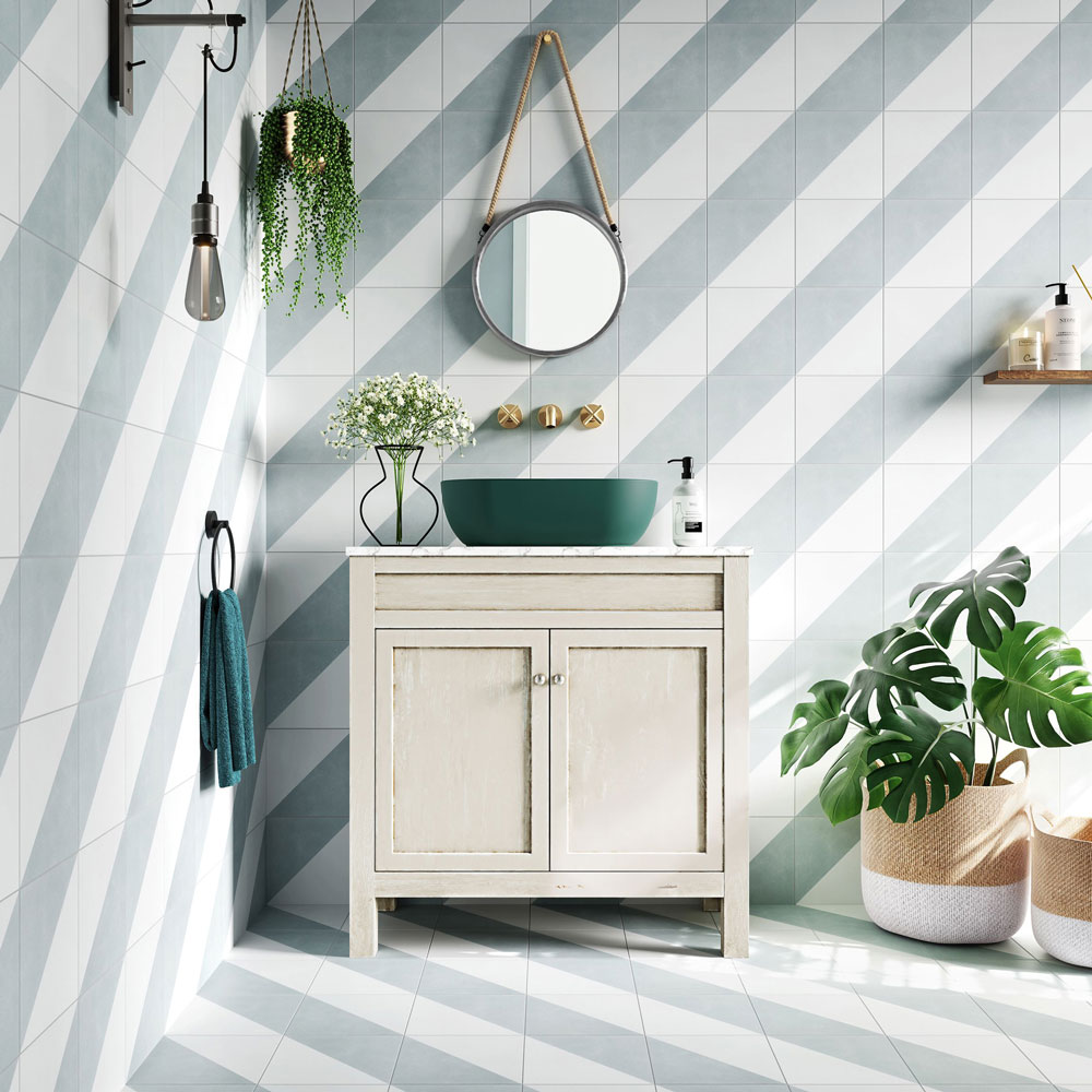 Light green and white diagonal stripe tile on walls and floors with green bathroom accessories.