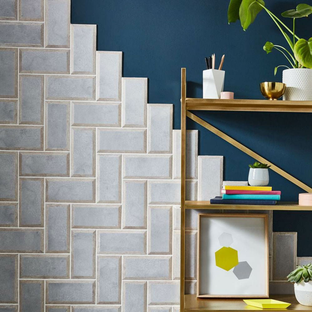 Navy blue wall paint with concrete and wood effect metro tiles in unique layout creeping up the wall. 