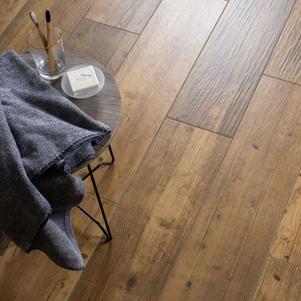Natural oak wood effect floor tiles with stool to the side.
