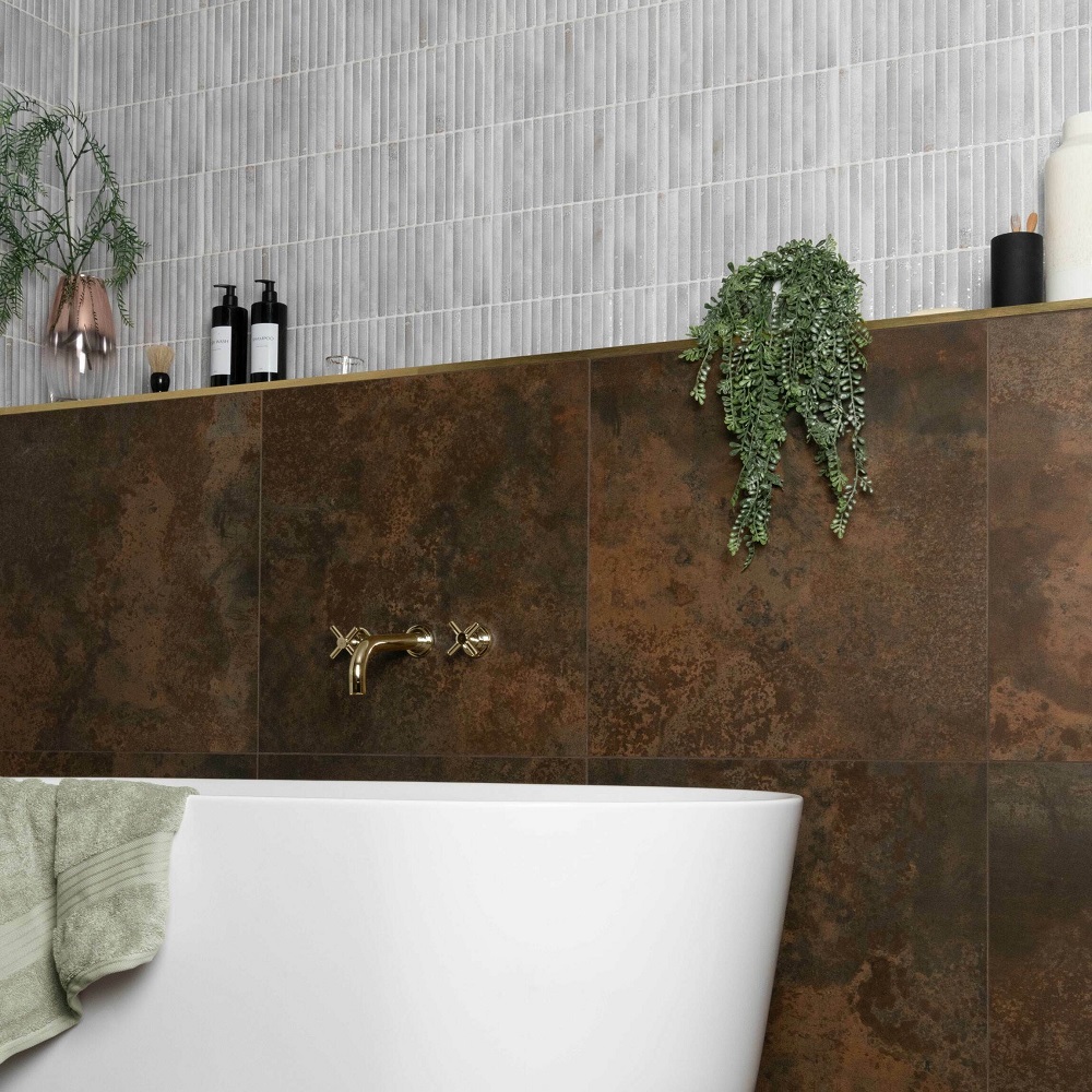 Rust tiles along wall in bathroom with gold hardware and plants to style the space. 