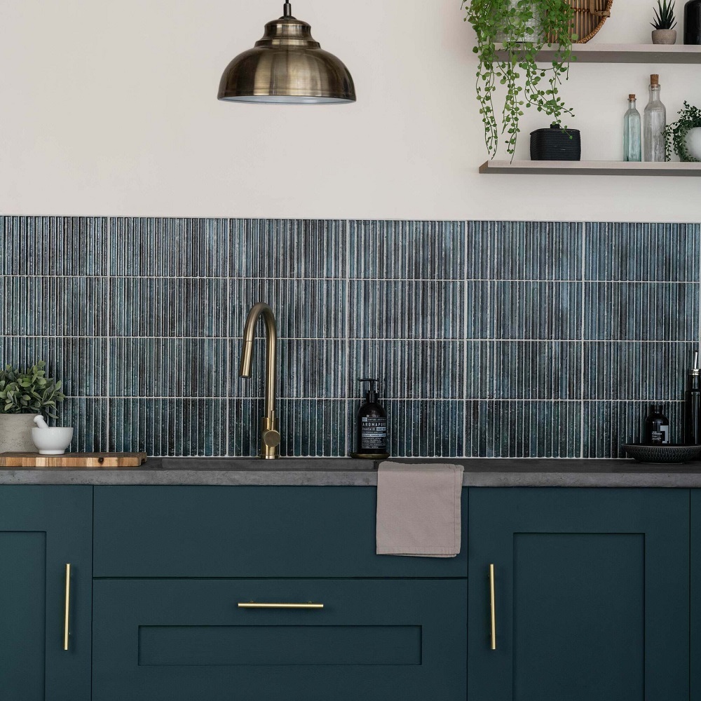 Meraki Kitt-Kat Marine dark blue tile along backsplash of kitchen styled with grey paint and navy blue kitchen cupboards. Gold accessories throughout to compliment.