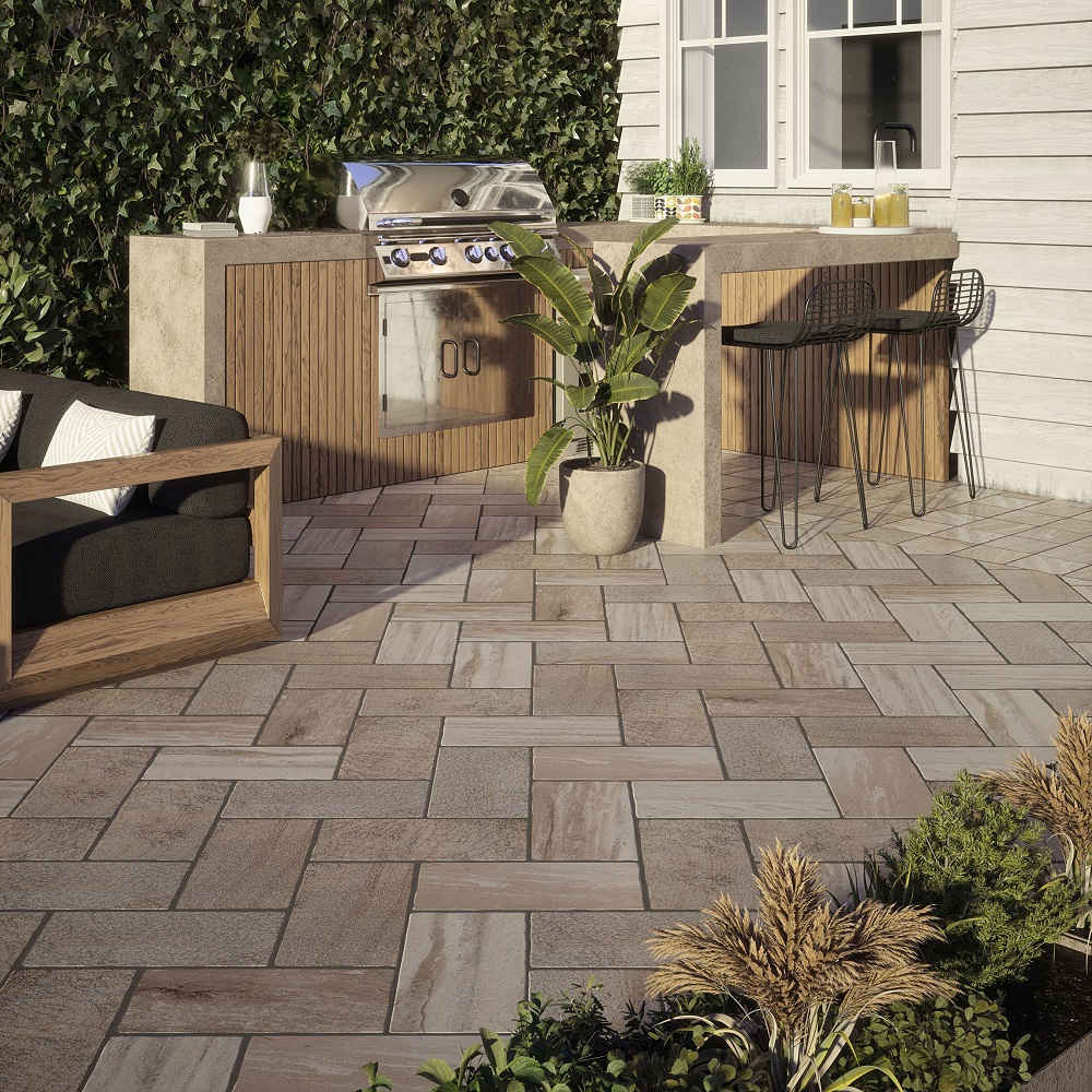 Neutral stone effect slab tiles across outdoor kitchen space with outdoor BBQ and stone effect countertops. 
