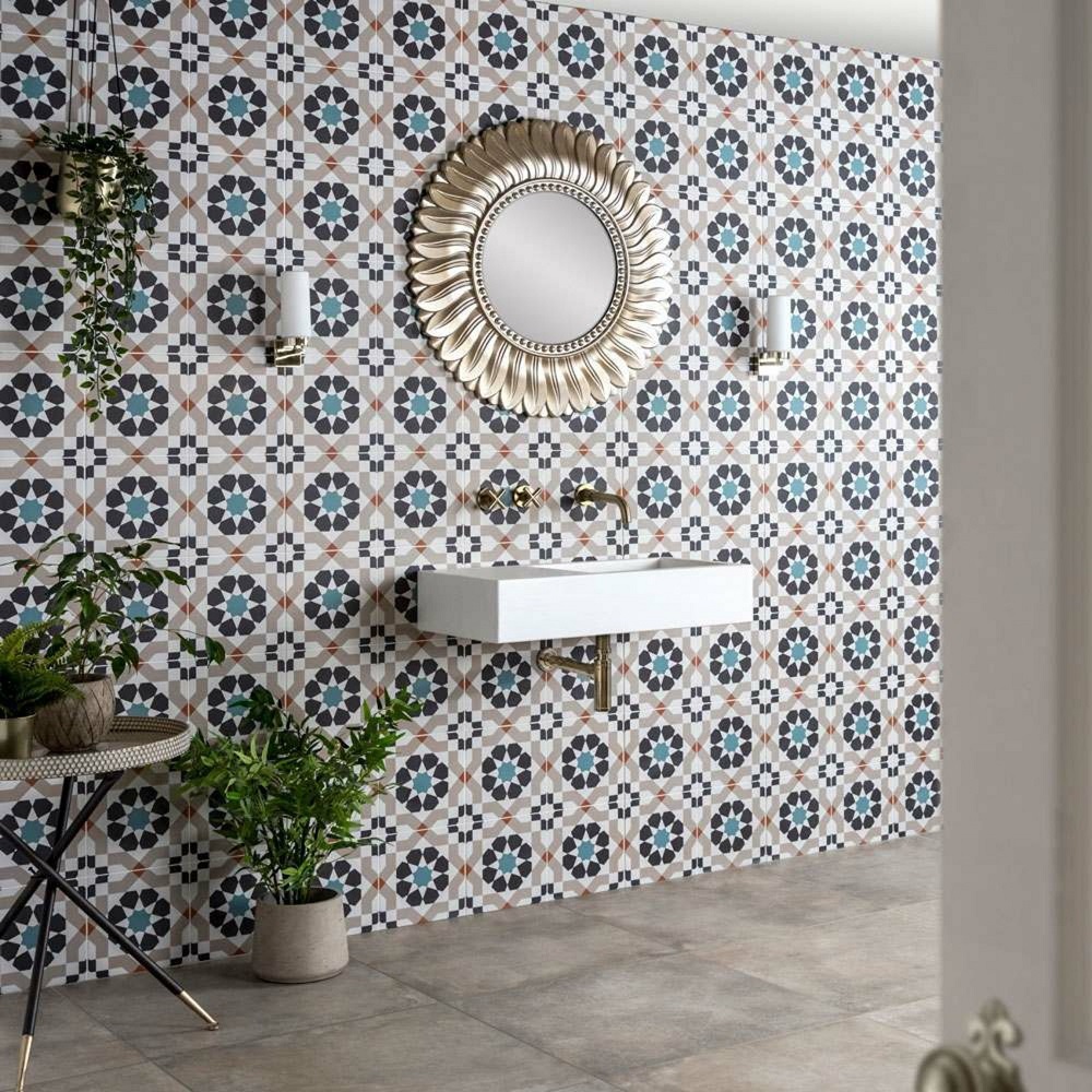 Colourful patterned wall tile with gold hardware details throughout sink area, grey stone effect floor tile. 