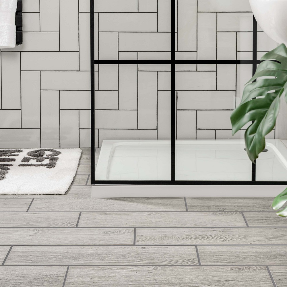Wood effect small size grey floor tiles working around shower tray with matt black shower screen.