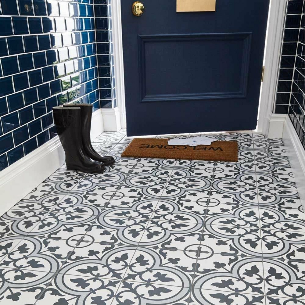 Dark blue and white pattern floor tiles in entryway of home with matching navy blue metro wall tiles and navy blue front door. 