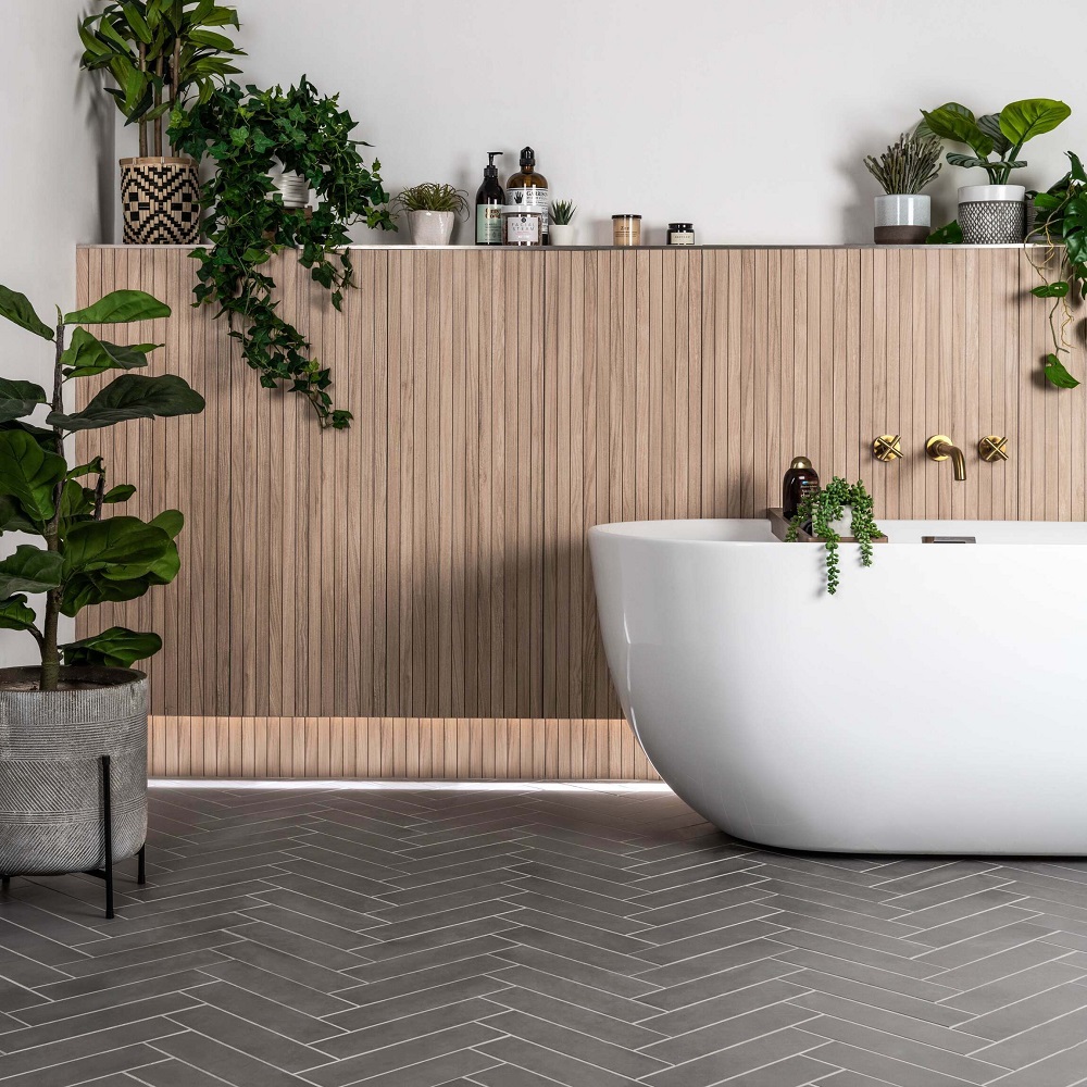 Light wood slat wall tiles mimic wall panels in bathroom with plethora of plants and products. 