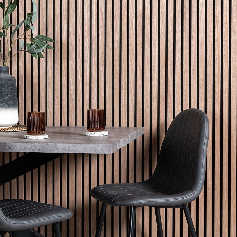 Dining area with table and chairs with light wood slat wall panels on wall alongside. 