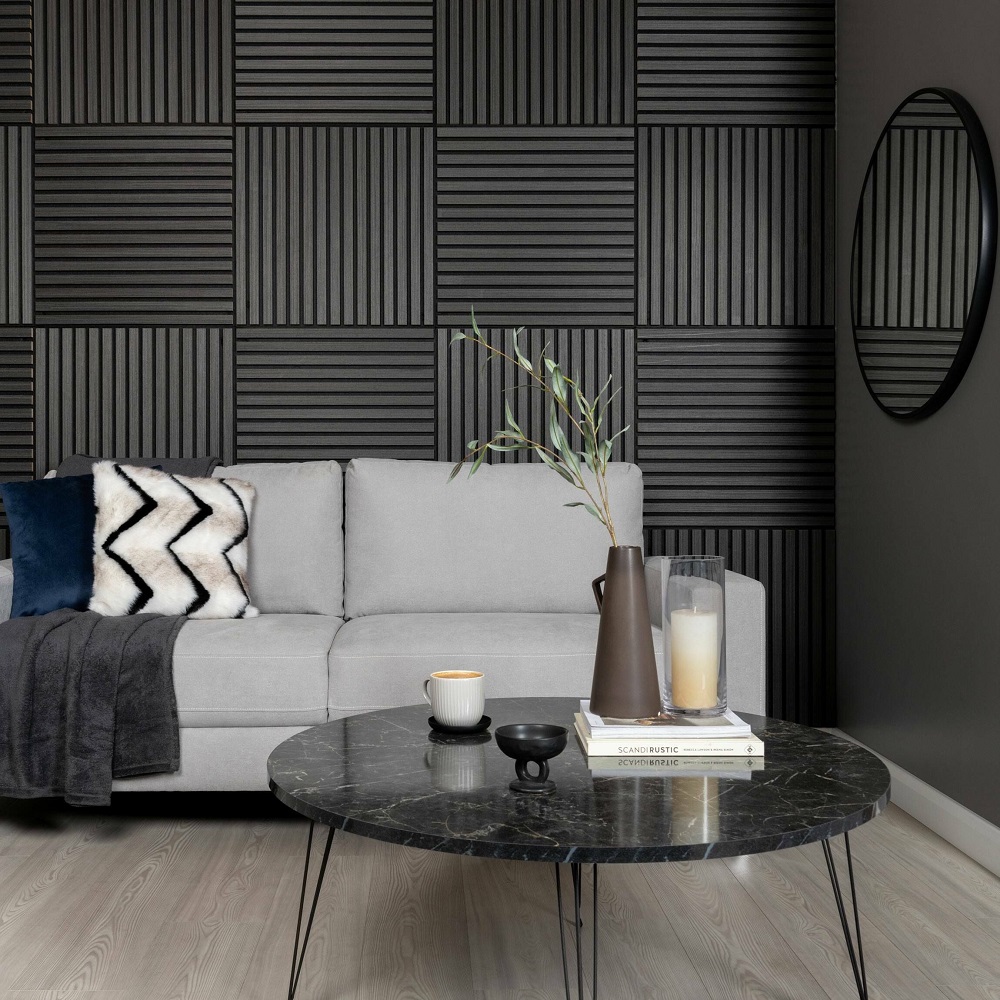 Stylish living room with noir square wood slat panels, grey sofa with decorative cushions, round marble coffee table with modern accessories, and an elegant round wall mirror.