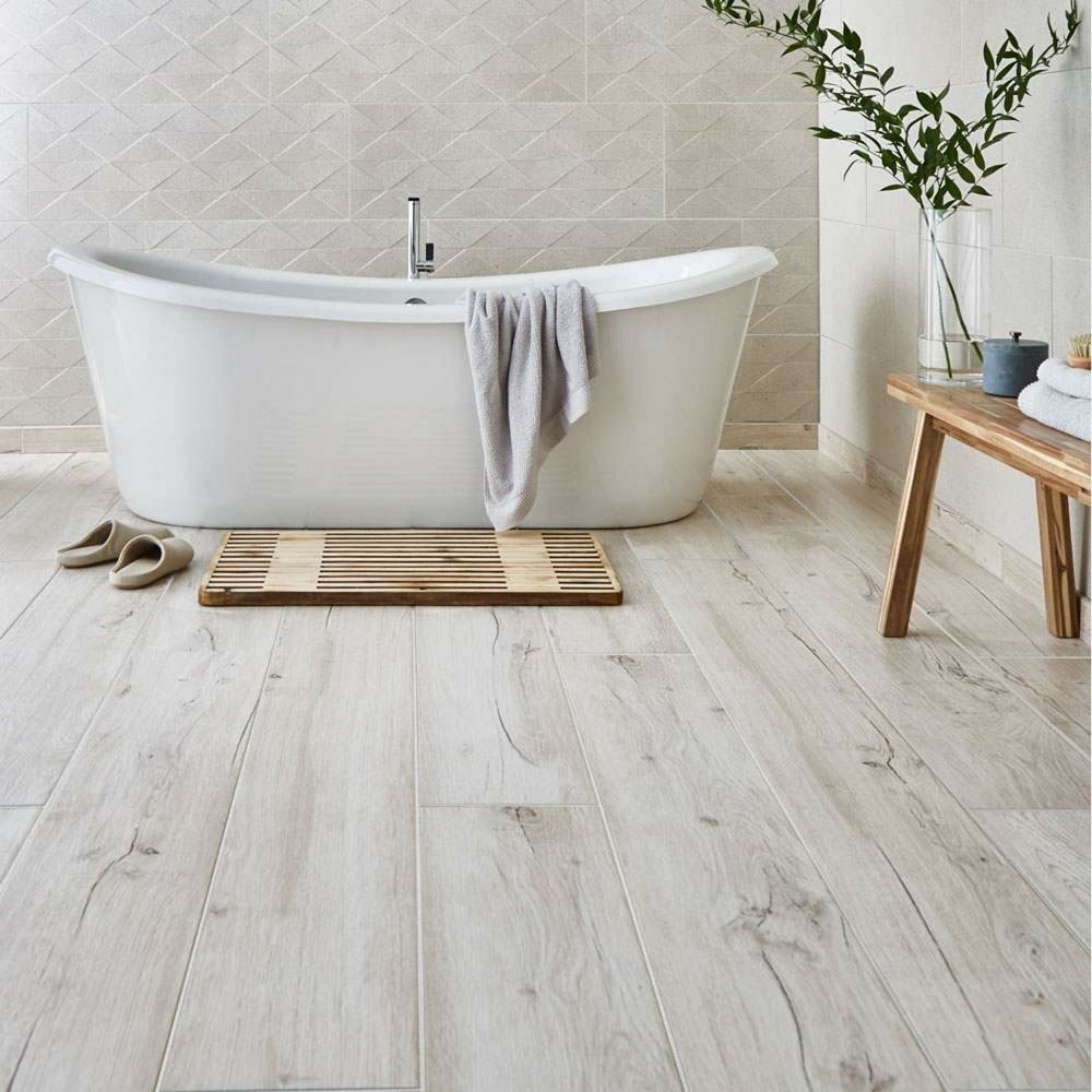 Serene bathroom oasis featuring light oak floor tiles for a bright, airy feel, with a freestanding bathtub, minimalist wooden bench, and lush greenery creating a perfect blend of nature inspired tranquillity and modern design. 