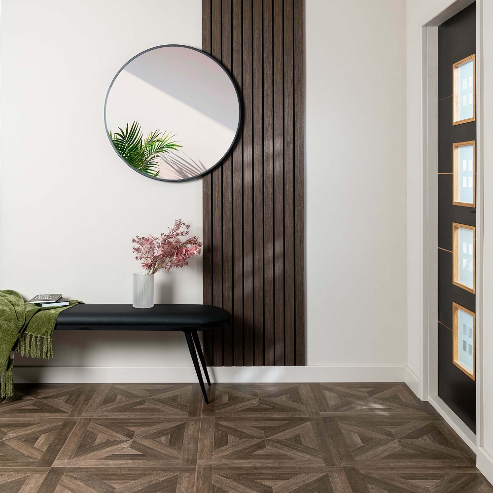 Modern hallway featuring Empire parquet wood tiles that add an element of sophisticated charm, perfectly complemented by the sleek black bench, round mirror and vertical wooden slats on the wall. 