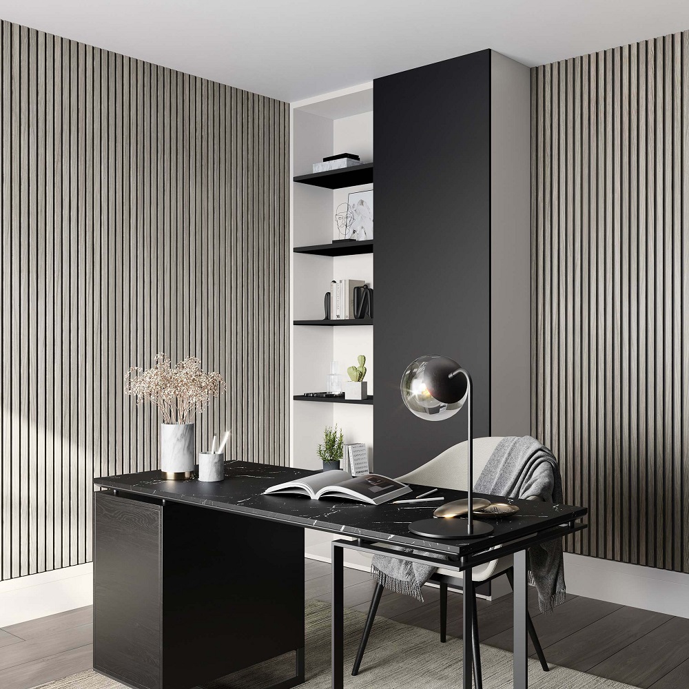 Contemporary home office space with minimalist design. The room is adorned with silver grey wood slat wall panels on two sides, adding texture and a modern touch to the space. A black desk is centred in the room, with a stylish globe desk lamp providing focused illumination. On the desk, there's an open book, a notepad, and a small vase with dried flowers, suggesting a blend of aesthetics and functionality. A comfortable chair with a throw blanket is subtly placed beside the desk, offering a spot for relaxation or reading. The room also features a black column that adds a bold contrast to the striped walls. Floating shelves on the right wall hold a few decorative items and books, maintaining the room's sleek and organised appearance. 