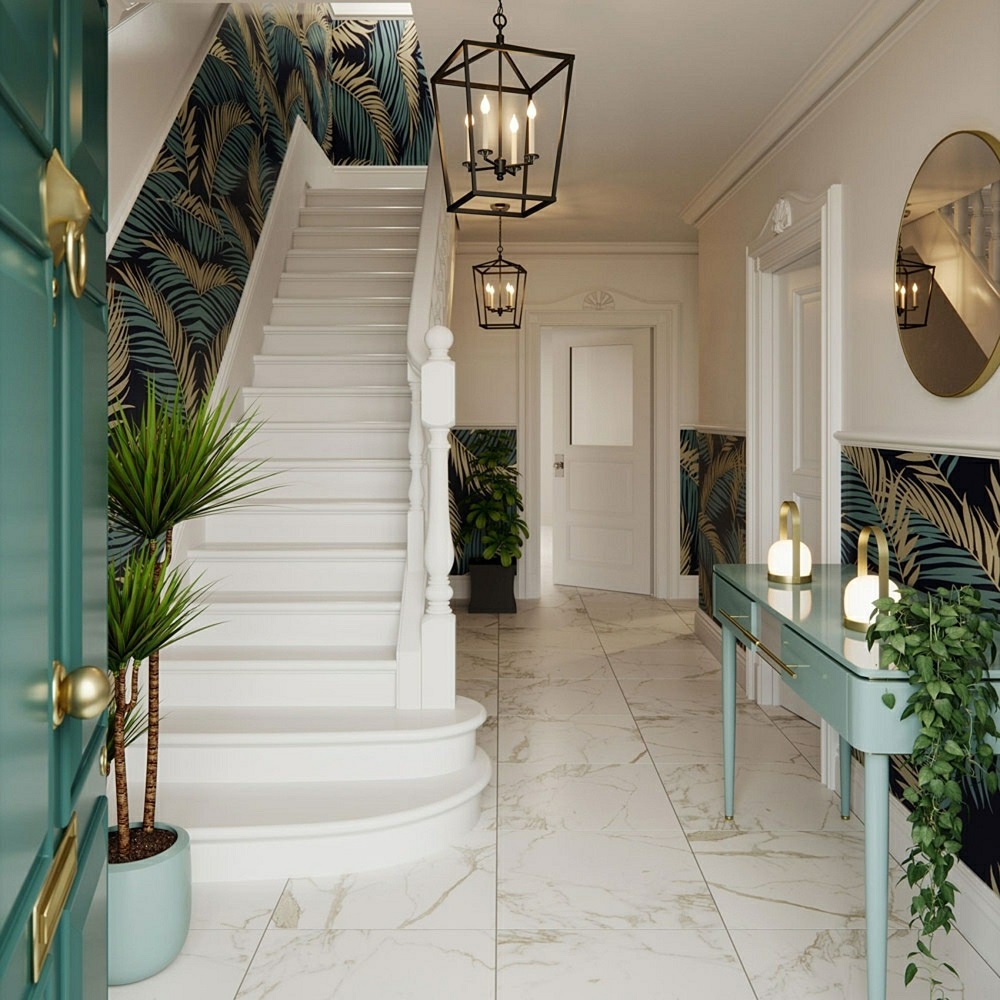 A grand and sophisticated entryway bathed in natural light, boasting Cappella Gold marble-effect tiles for a luxurious, airy feel. The sweeping white staircase with its refined balusters is accented by a bold tropical wallpaper, creating an exotic contrast. Gold hardware on the teal door adds a touch of opulence, mirroring the golden tones in the console table and the elegant twin pendant lights above. Plush potted greenery throughout enhances the space's fresh and welcoming atmosphere, while a round mirror strategically reflects the room's classic charm.
