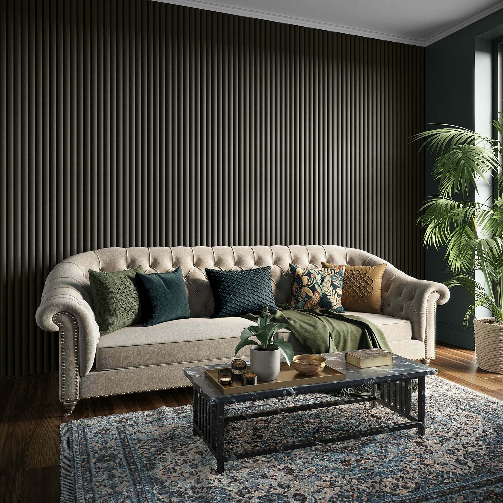A luxurious living room scene with a noir black curved panel wall providing a skirting backdrop to a classic tufted sofa in a neutral tone. The sofa is adorned with an array of cushions in various textures and shades of green and mustard, adding a cosy touch. In font, a vintage style coffee table holds decorative items and books. A traditional patterned rug adds colour to the wooden floor, and a lush potted palm brings a sense of vitality to the space. 